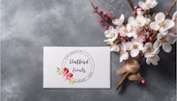 a card with flowers and a branch on a gray background